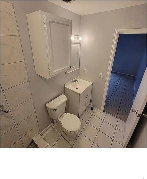 bathroom featuring toilet, vanity, and tile patterned floors