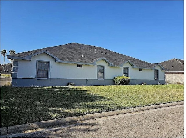 view of front of home with a shingled roof and a front yard