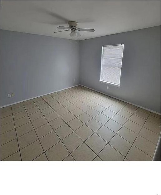 spare room featuring light tile patterned floors and a ceiling fan