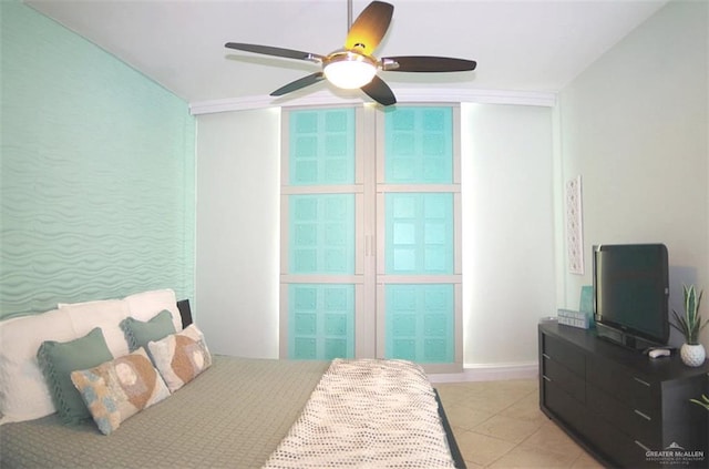 bedroom featuring light tile patterned flooring, a ceiling fan, and baseboards