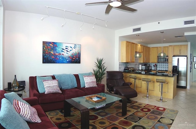 living room featuring light tile patterned floors, visible vents, and ceiling fan