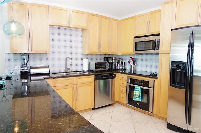 kitchen featuring light brown cabinets, appliances with stainless steel finishes, backsplash, and a sink