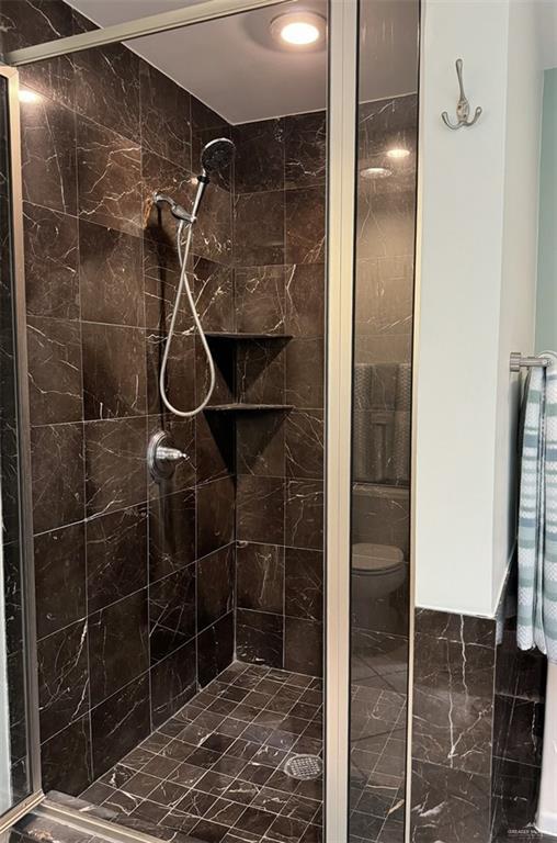 full bath with a shower stall and toilet