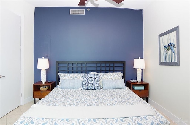tiled bedroom with visible vents, ceiling fan, and baseboards