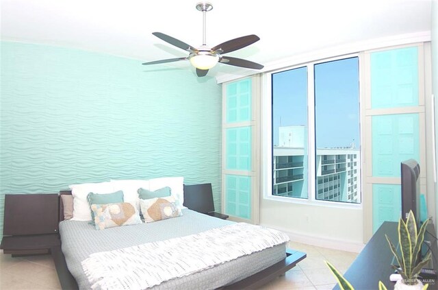 tiled bedroom featuring ceiling fan and baseboards