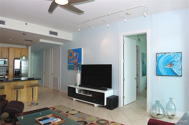 living room featuring light tile patterned flooring, ceiling fan, and visible vents