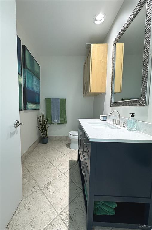bathroom featuring vanity, toilet, and baseboards