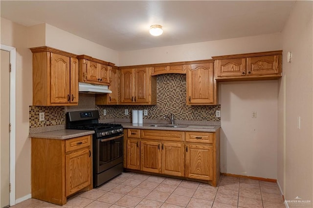 2512 Dallas Ave, Mcallen, TX 78501 - kitchen with stainless steel gas stove, under cabinet range hood, backsplash, and brown cabinetry