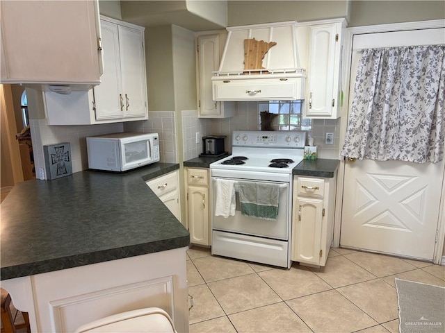 kitchen with ventilation hood, dark countertops, light tile patterned floors, and white appliances