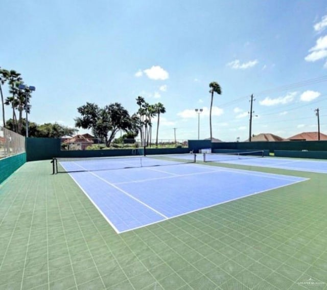 view of tennis court with fence and community basketball court