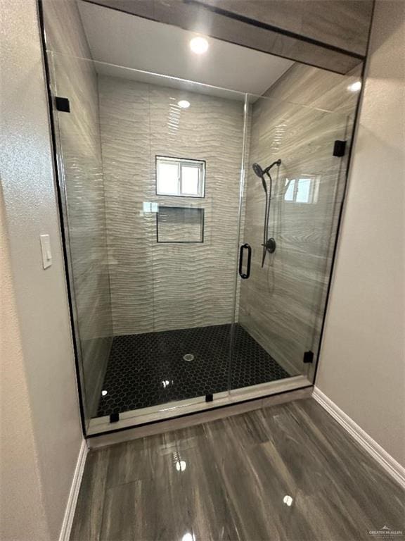 bathroom featuring hardwood / wood-style flooring and a shower with shower door