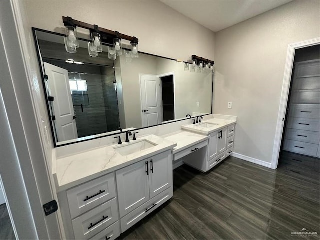 bathroom with hardwood / wood-style floors, vanity, and a shower with shower door