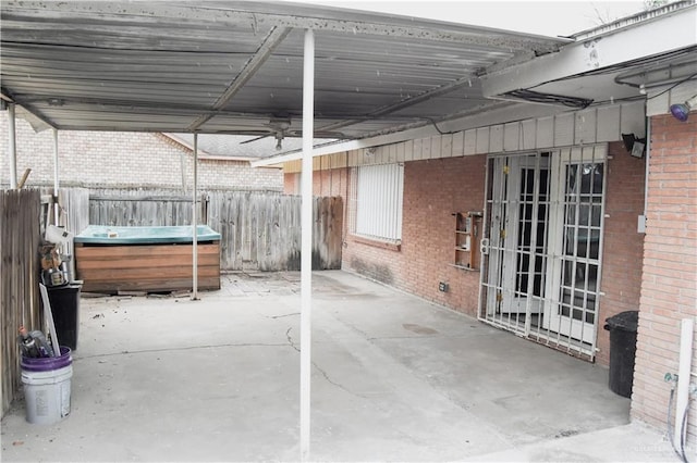 view of patio / terrace featuring ceiling fan and a hot tub