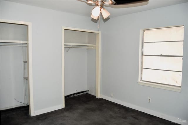 unfurnished bedroom featuring ceiling fan, dark carpet, and a closet