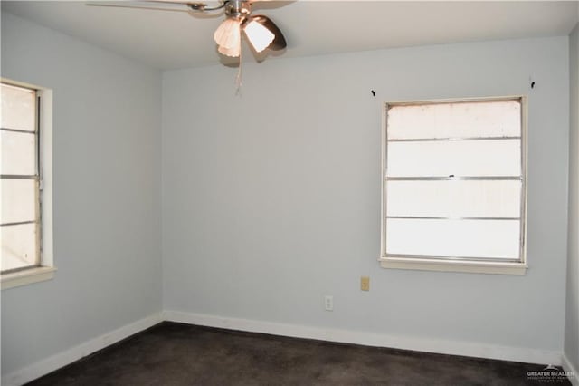 unfurnished room with ceiling fan, plenty of natural light, and dark carpet