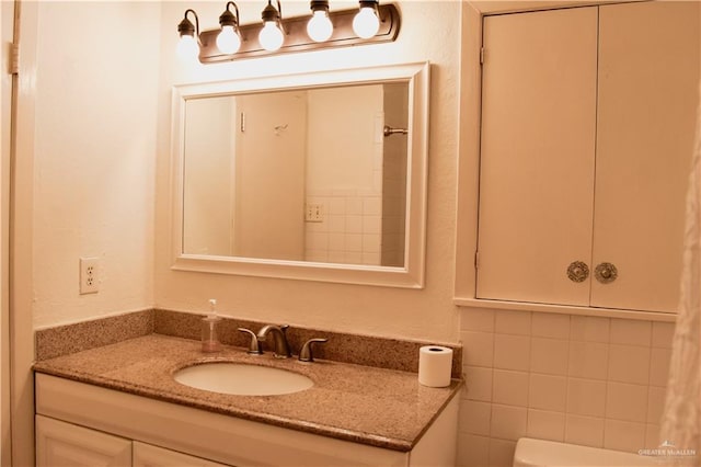 bathroom featuring vanity and tile walls