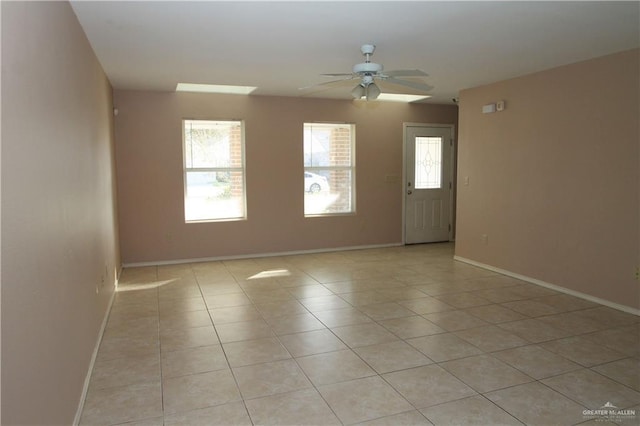 tiled empty room featuring ceiling fan