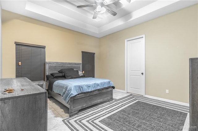 bedroom with ceiling fan, light tile patterned flooring, and a raised ceiling