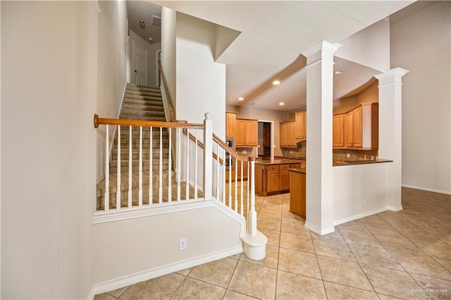 stairway with visible vents, baseboards, recessed lighting, ornate columns, and tile patterned flooring