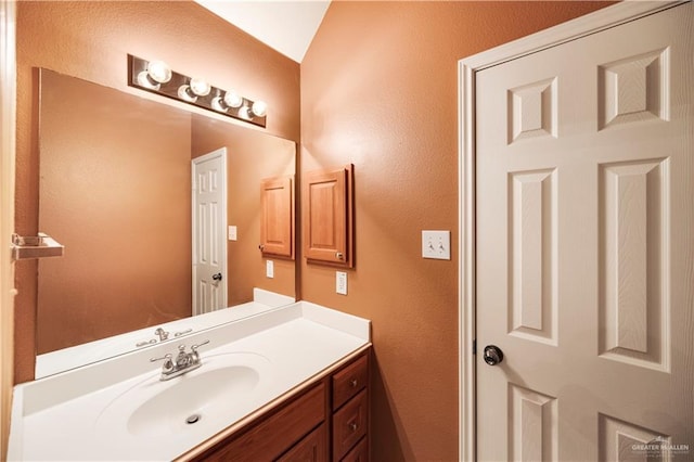bathroom featuring a textured wall and vanity