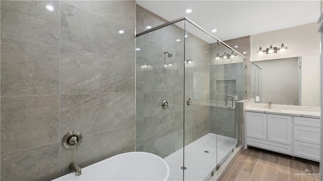 bathroom with independent shower and bath, vanity, and hardwood / wood-style flooring