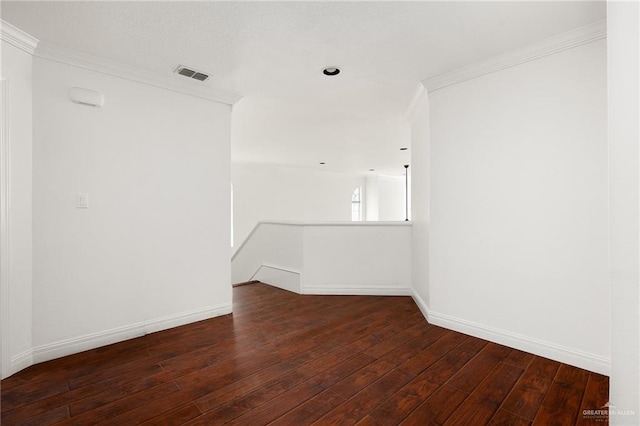 empty room featuring dark hardwood / wood-style flooring and crown molding