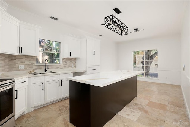 kitchen featuring white cabinets, stainless steel stove, and a kitchen island