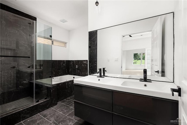 bathroom featuring vanity and independent shower and bath