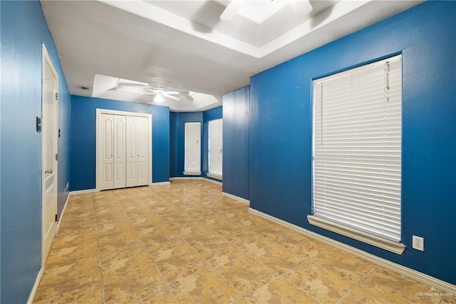 unfurnished bedroom with a closet, a ceiling fan, and baseboards