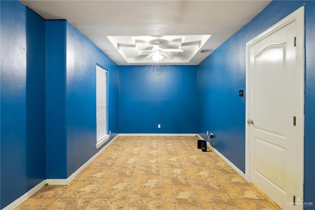 unfurnished room with a tray ceiling, visible vents, ceiling fan, and baseboards