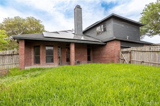 back of house featuring solar panels