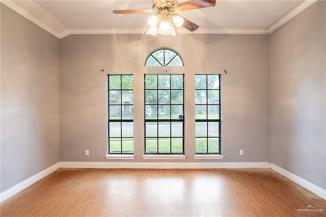 empty room featuring ceiling fan, crown molding, and light wood-type flooring