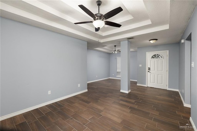 entryway featuring visible vents, ceiling fan, baseboards, wood finish floors, and a raised ceiling