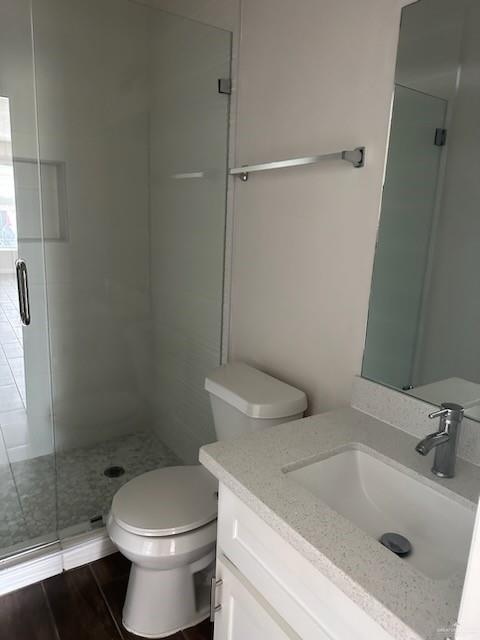 bathroom with vanity, wood-type flooring, an enclosed shower, and toilet