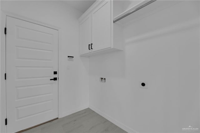 clothes washing area featuring hookup for an electric dryer, cabinets, light wood-type flooring, and hookup for a washing machine