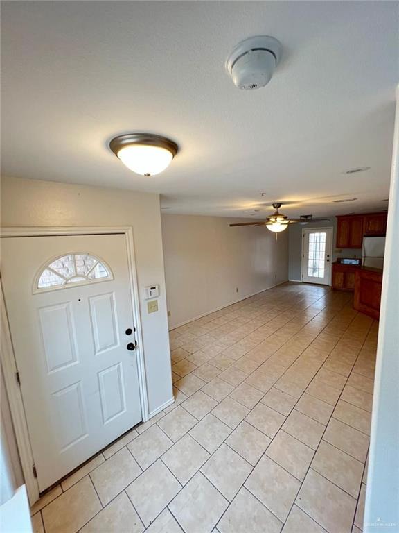 entryway featuring ceiling fan and light tile patterned flooring