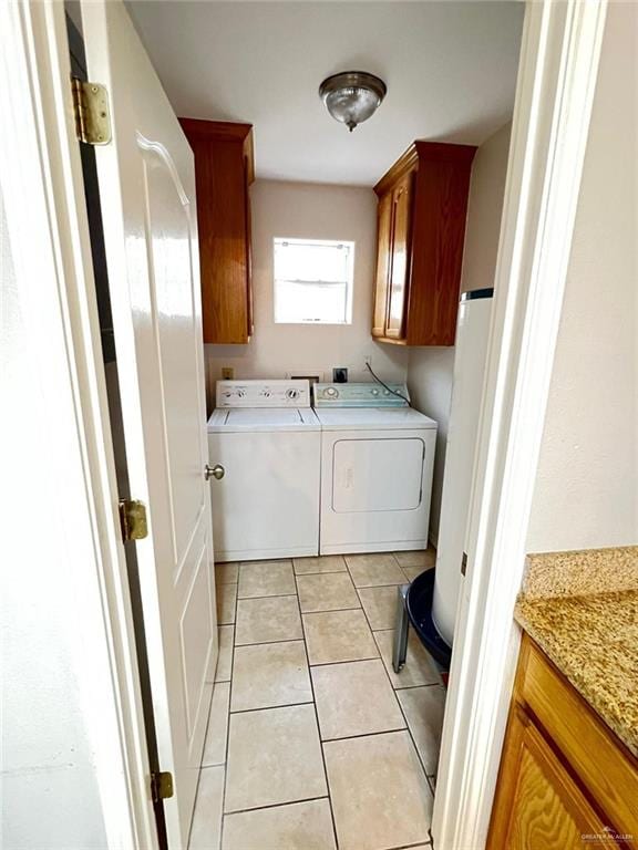 clothes washing area with cabinets, separate washer and dryer, and light tile patterned flooring