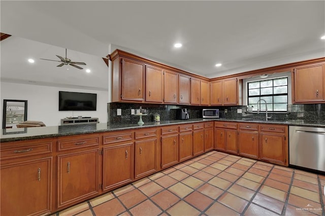 kitchen featuring sink, decorative backsplash, ceiling fan, light tile patterned floors, and appliances with stainless steel finishes