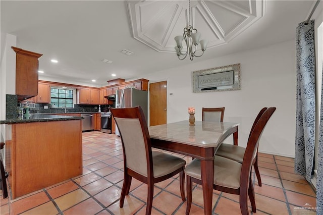 dining space featuring a chandelier, sink, and light tile patterned flooring