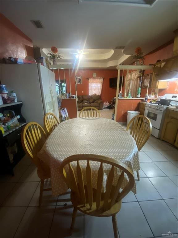 tiled dining space featuring ceiling fan