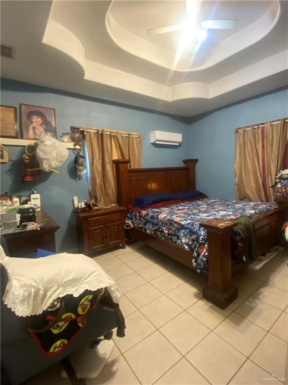 bedroom with ceiling fan, a raised ceiling, light tile patterned floors, and a wall mounted AC