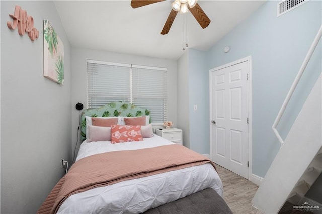 bedroom with ceiling fan, vaulted ceiling, and light hardwood / wood-style flooring