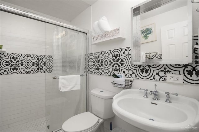 bathroom featuring tasteful backsplash, toilet, an enclosed shower, and sink