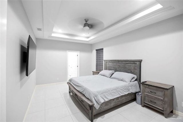 bedroom with a raised ceiling, ceiling fan, and light tile patterned flooring