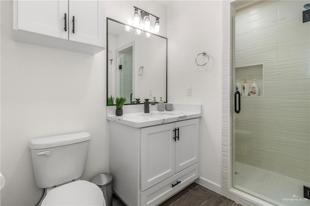 bathroom featuring vanity, an enclosed shower, and toilet