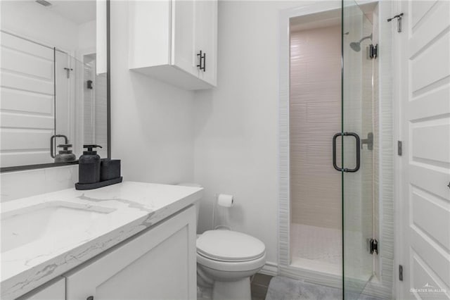 bathroom with vanity, an enclosed shower, and toilet