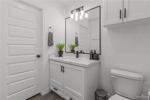 bathroom featuring vanity, hardwood / wood-style floors, and toilet