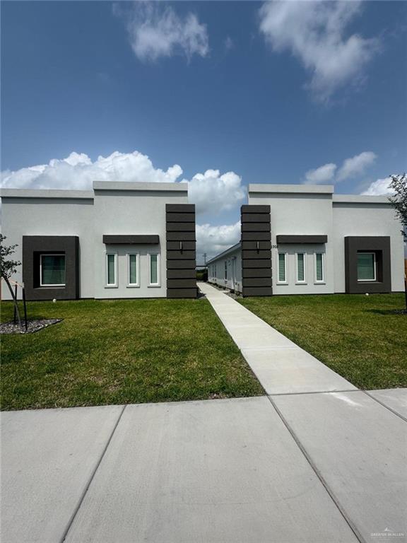 view of front of house featuring stucco siding and a front yard