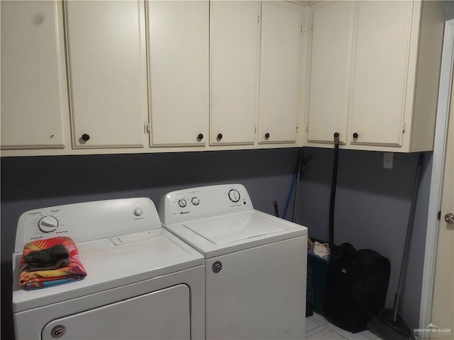 clothes washing area with cabinets and independent washer and dryer