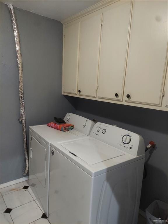 laundry room featuring cabinets, light tile patterned floors, and separate washer and dryer